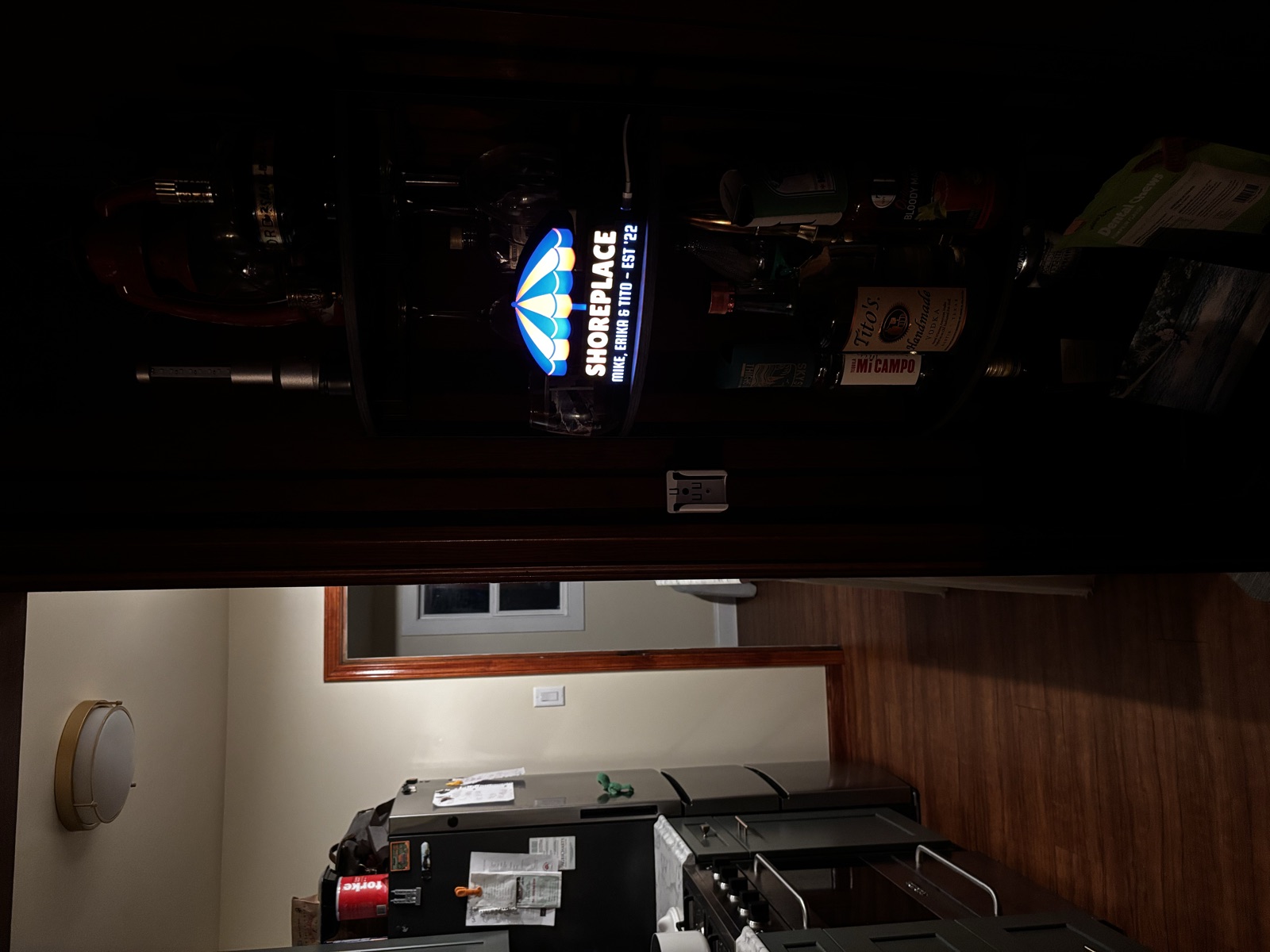 A wide shot of the lightbox glowing on the bar cart at the end of a hallway.