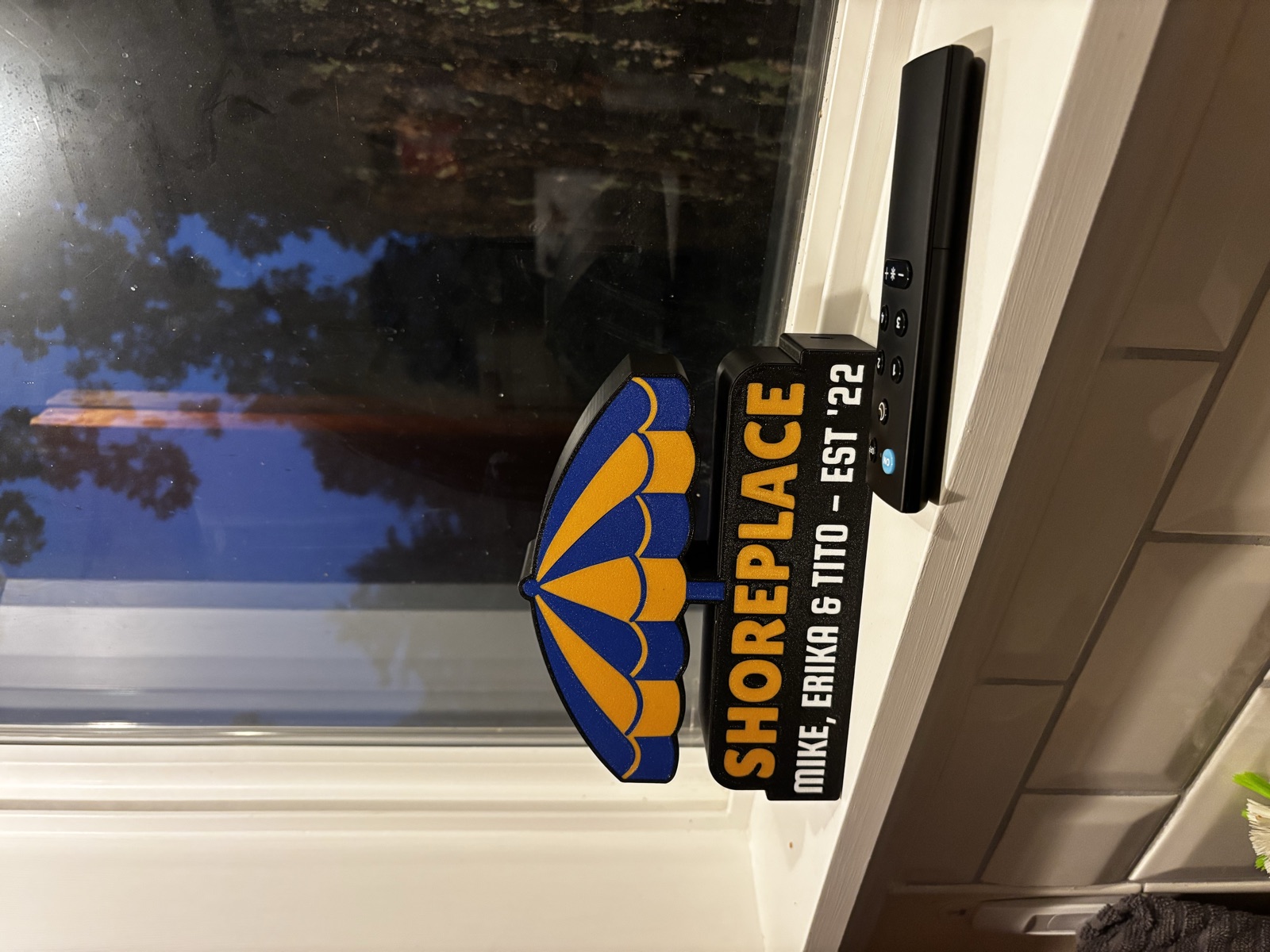 The Shoreplace lightbox on a windowsill next to its physical remote.